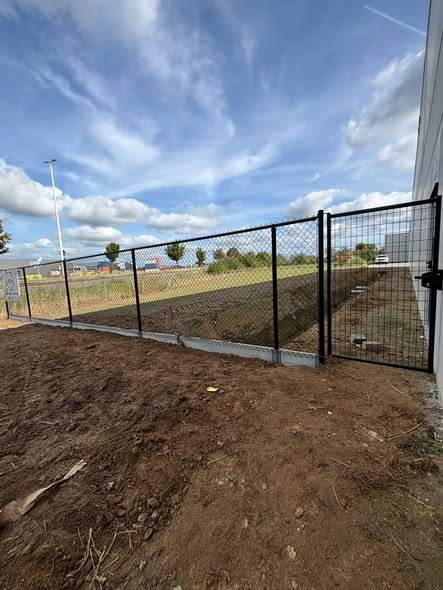 Draadhekwerk van 1,80 m op betonplaat, met poort.