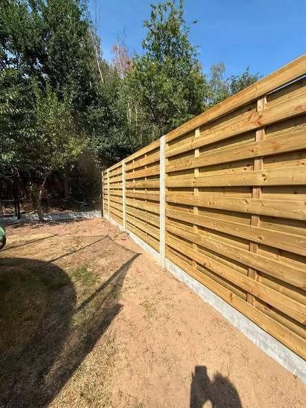 Houten schutsels op betonplaat rond de speeltuin.