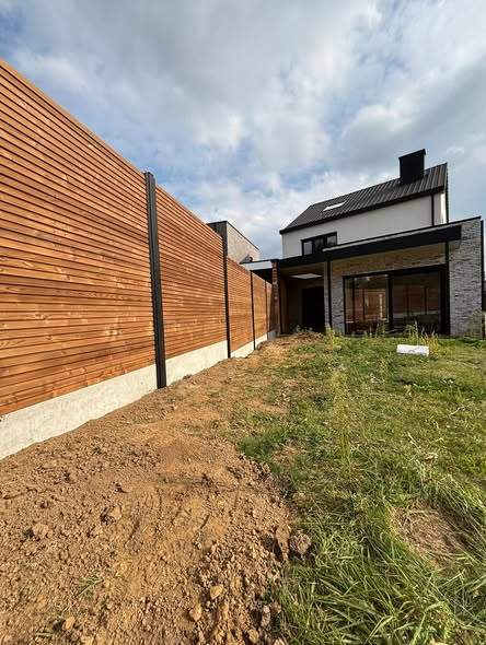 Thermowood hekwerk op zwarte palen.
