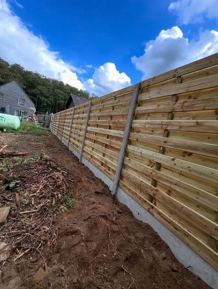 Houten schutsels op betonpalen.